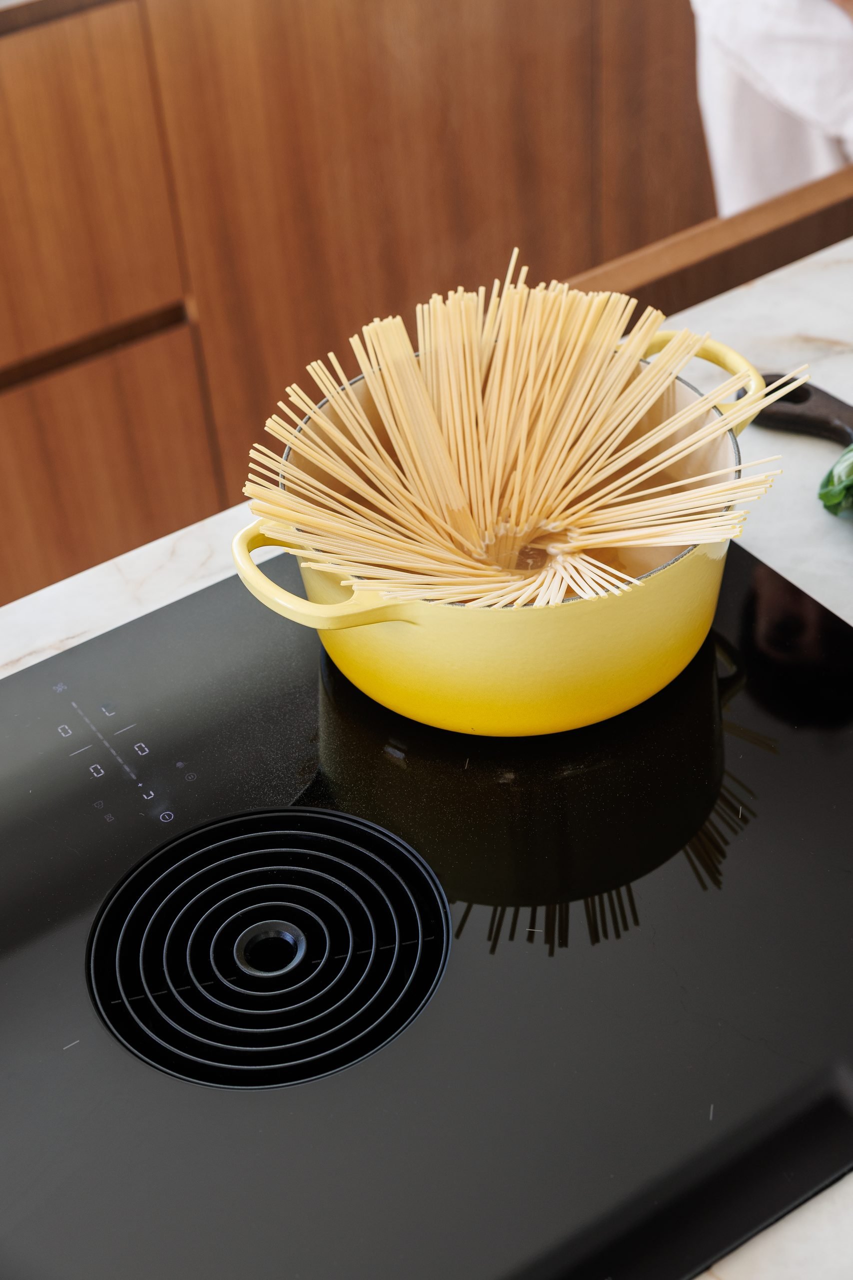 Olla amarilla con pasta sobre placa de inducción — B2 Invest Cocina, Costa del Sol. Fotografía de Pedro Jaén