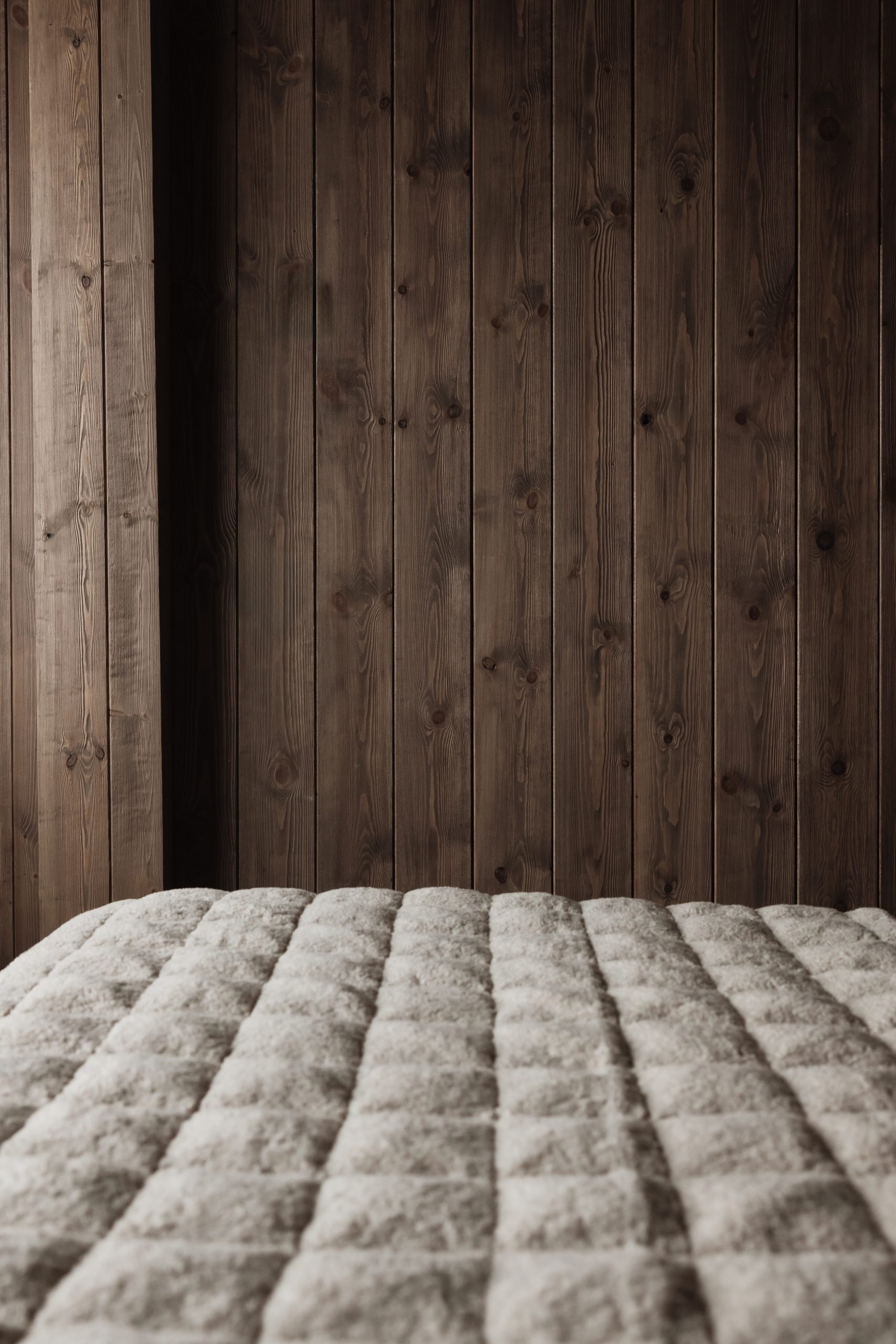 Detalle de colcha acolchada ante pared de madera — Casa Nevada Slalom, Sierra Nevada, Granada. Fotografía de Pedro Jaén