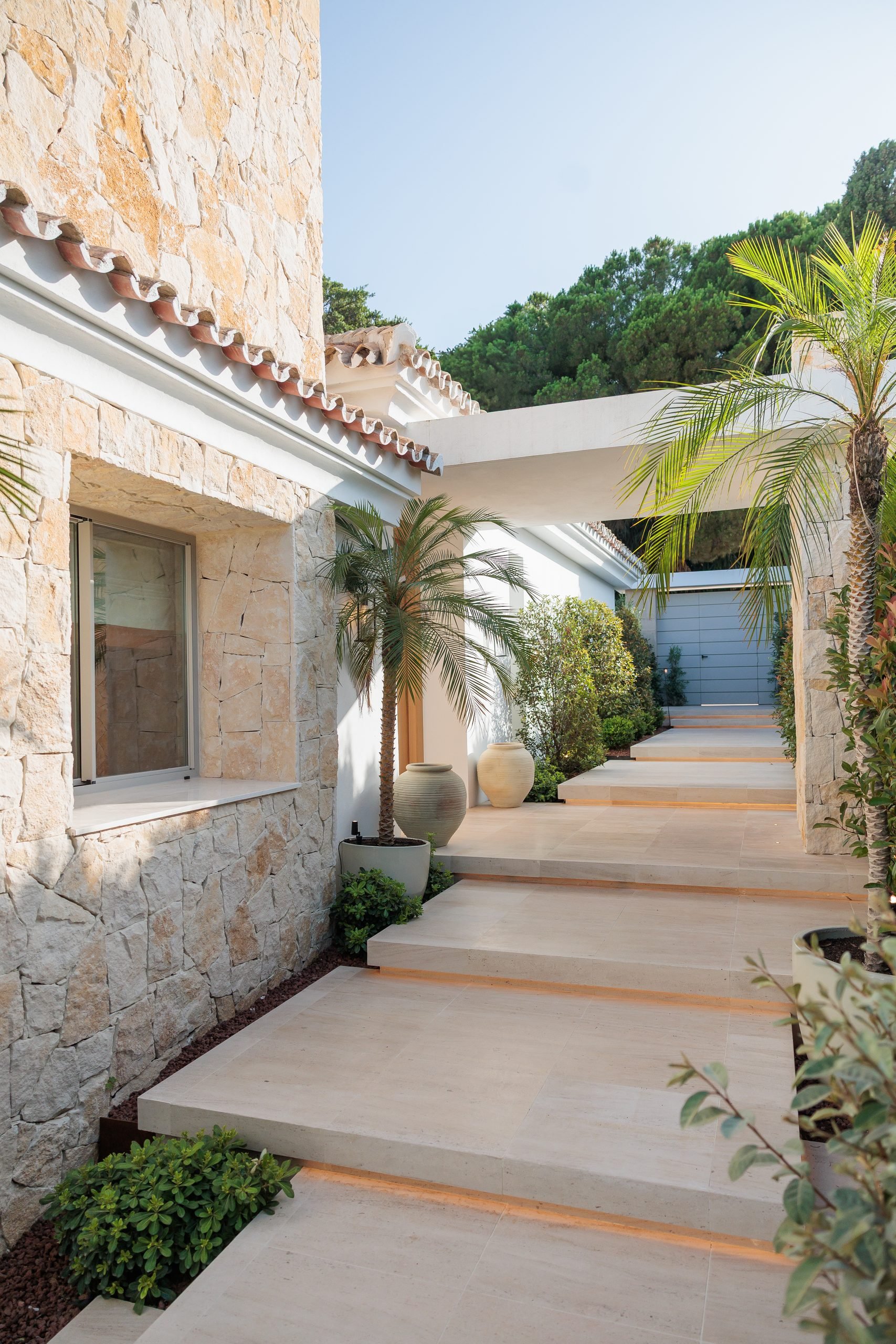 Escalera exterior de piedra entre muros y palmeras — CG Studio, Costa del Sol. Fotografía de Pedro Jaén