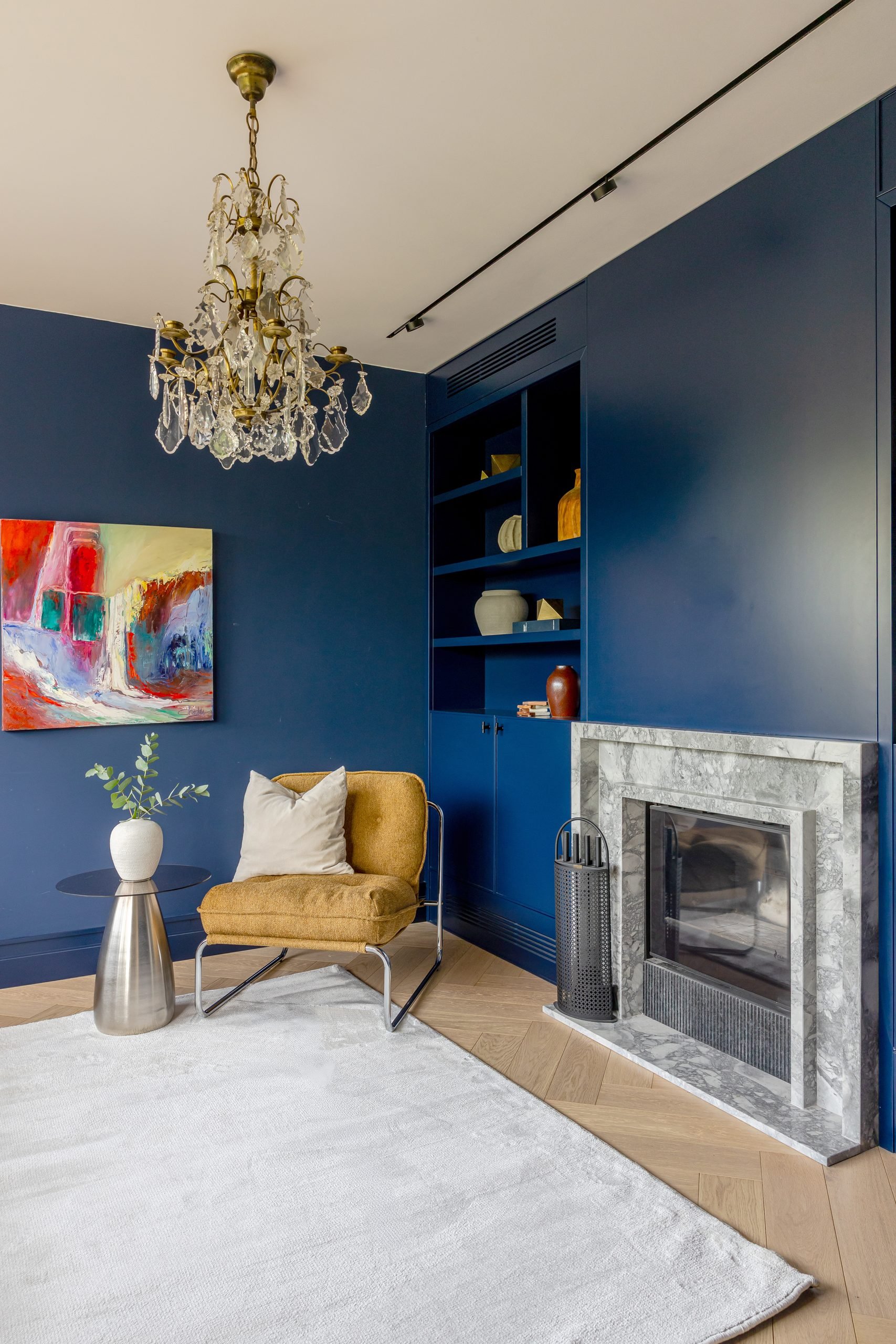 Salón azul con chimenea y lámpara de araña — Concept Living Caroline, Costa del Sol. Fotografía de Pedro Jaén