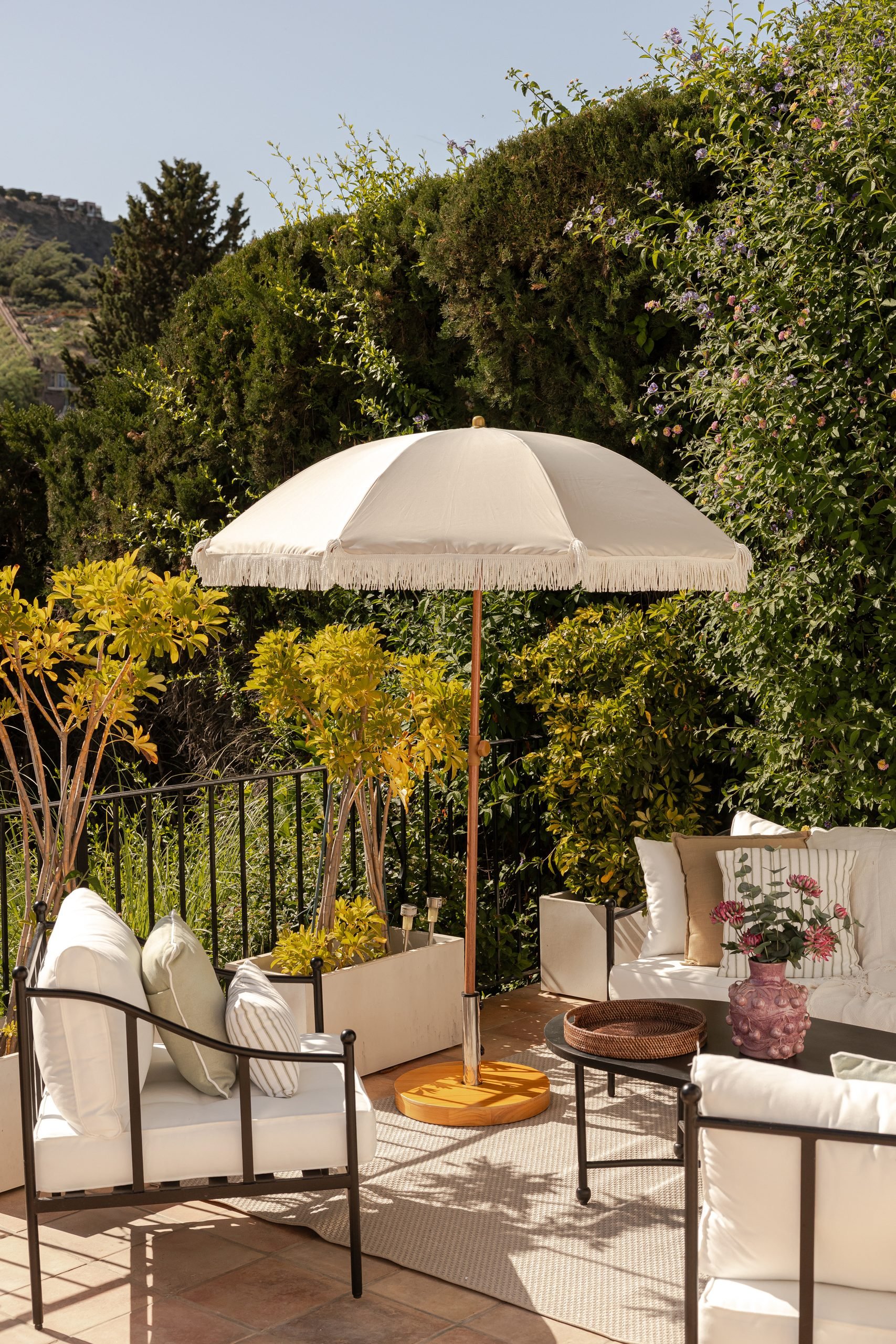 Terraza con sombrilla y butacas entre vegetación — Deco Caroline, Costa del Sol. Fotografía de Pedro Jaén