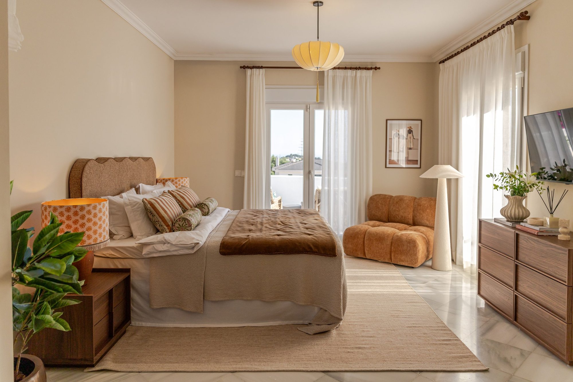 Dormitorio con cama, butacas y ventanal — Deco Caroline, Costa del Sol. Fotografía de Pedro Jaén