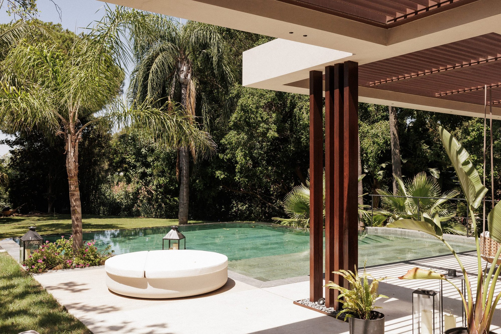Piscina con cama balinesa bajo pérgola de madera entre palmeras — Eacis Villa Lovina, Costa del Sol. Fotografía de Pedro Jaén