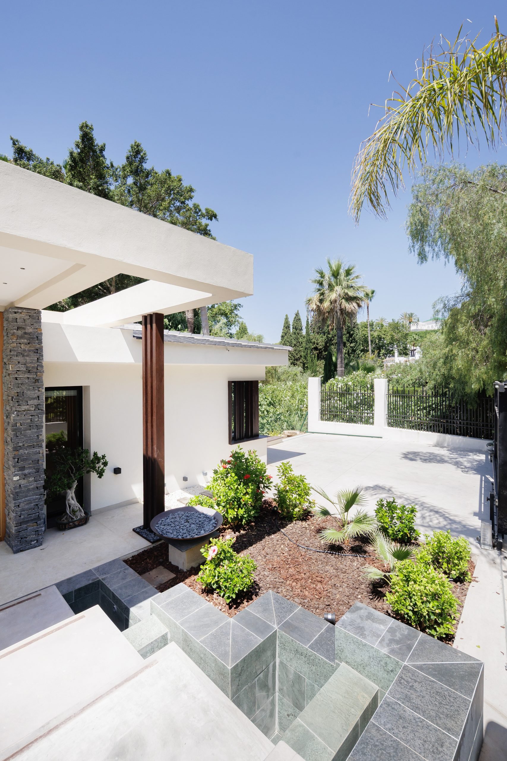 Patio interior con jardinera y fachada blanca — Eacis Villa Lovina, Costa del Sol. Fotografía de Pedro Jaén