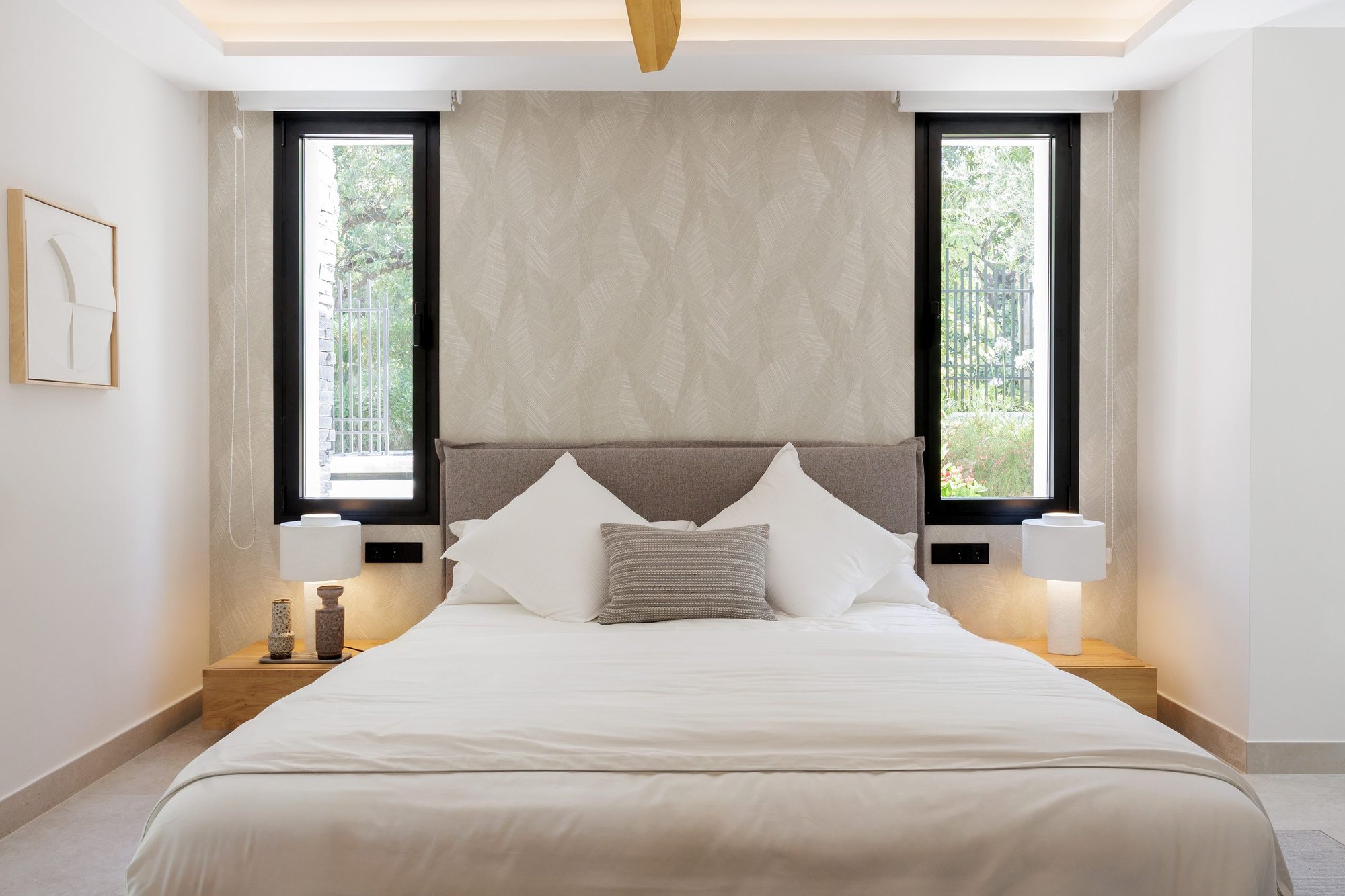 Dormitorio con cabecero tapizado y ventanas verticales — Eacis Villa Lovina, Costa del Sol. Fotografía de Pedro Jaén