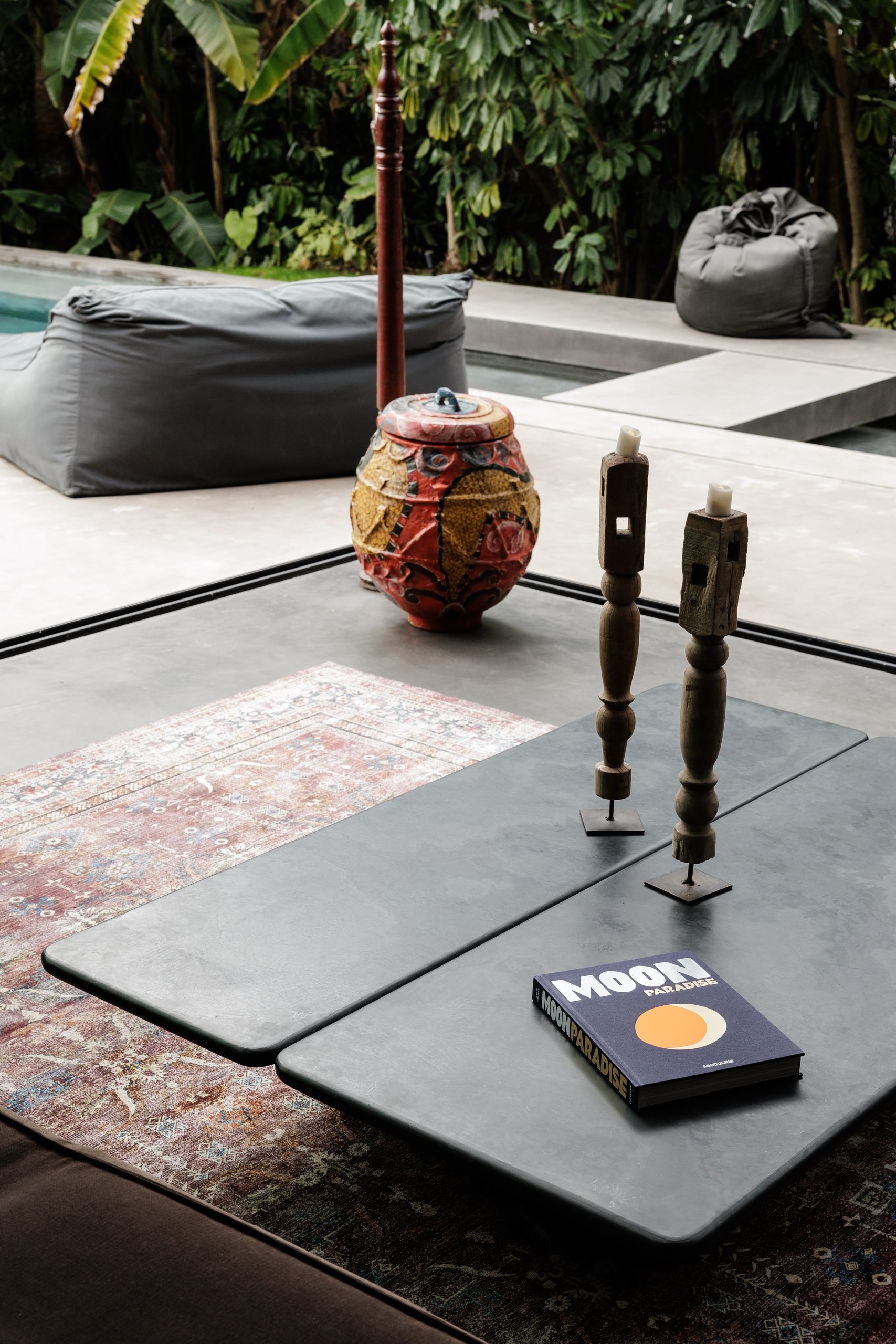 Mesa baja de piedra oscura con vasija artesana y candelabros — Endless Grahana Soul Corzo 5, Costa del Sol. Fotografía de Pedro Jaén