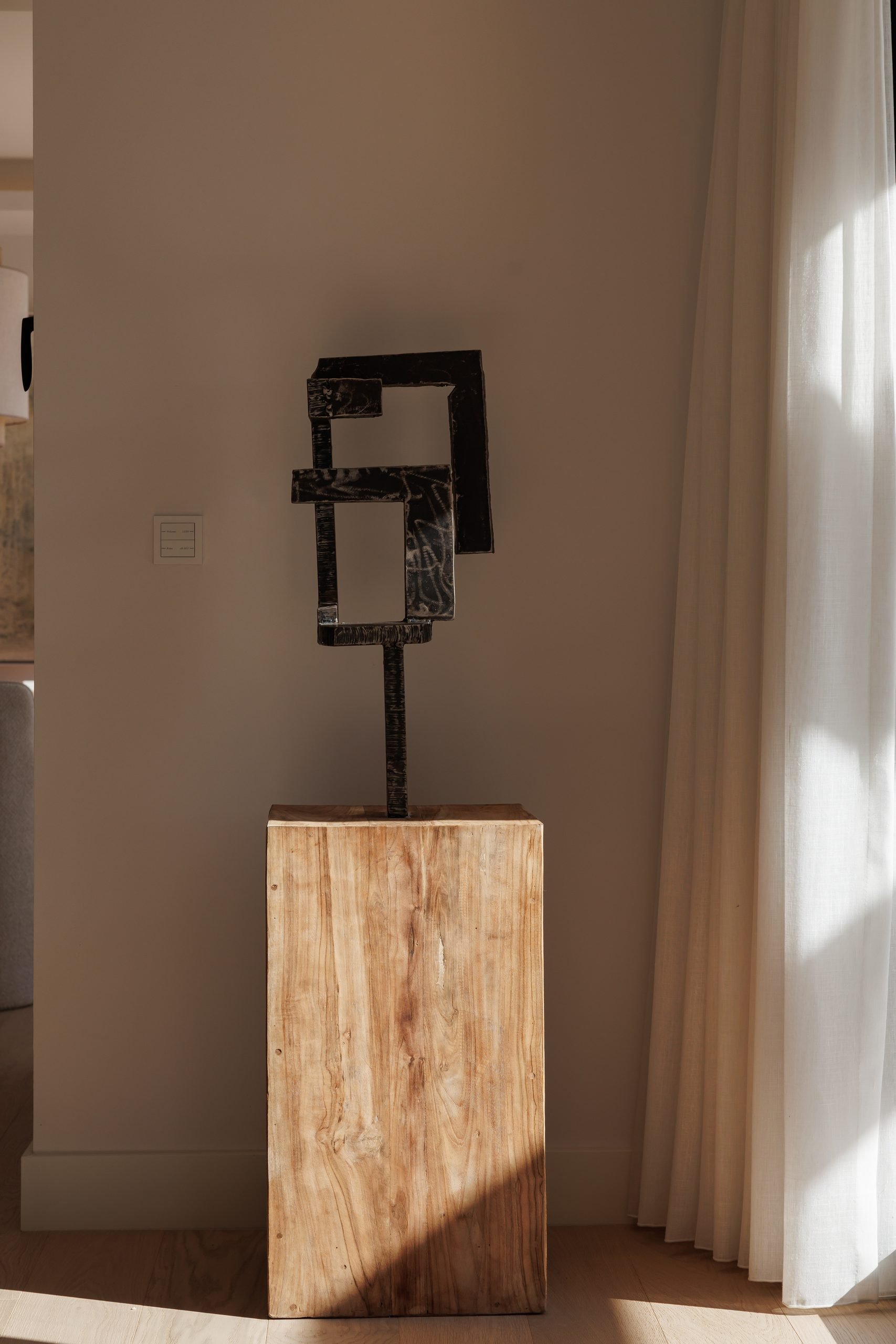 Escultura de metal sobre peana de madera junto a la ventana — González Casaus Poniente, Poniente, Marbella. Fotografía de Pedro Jaén