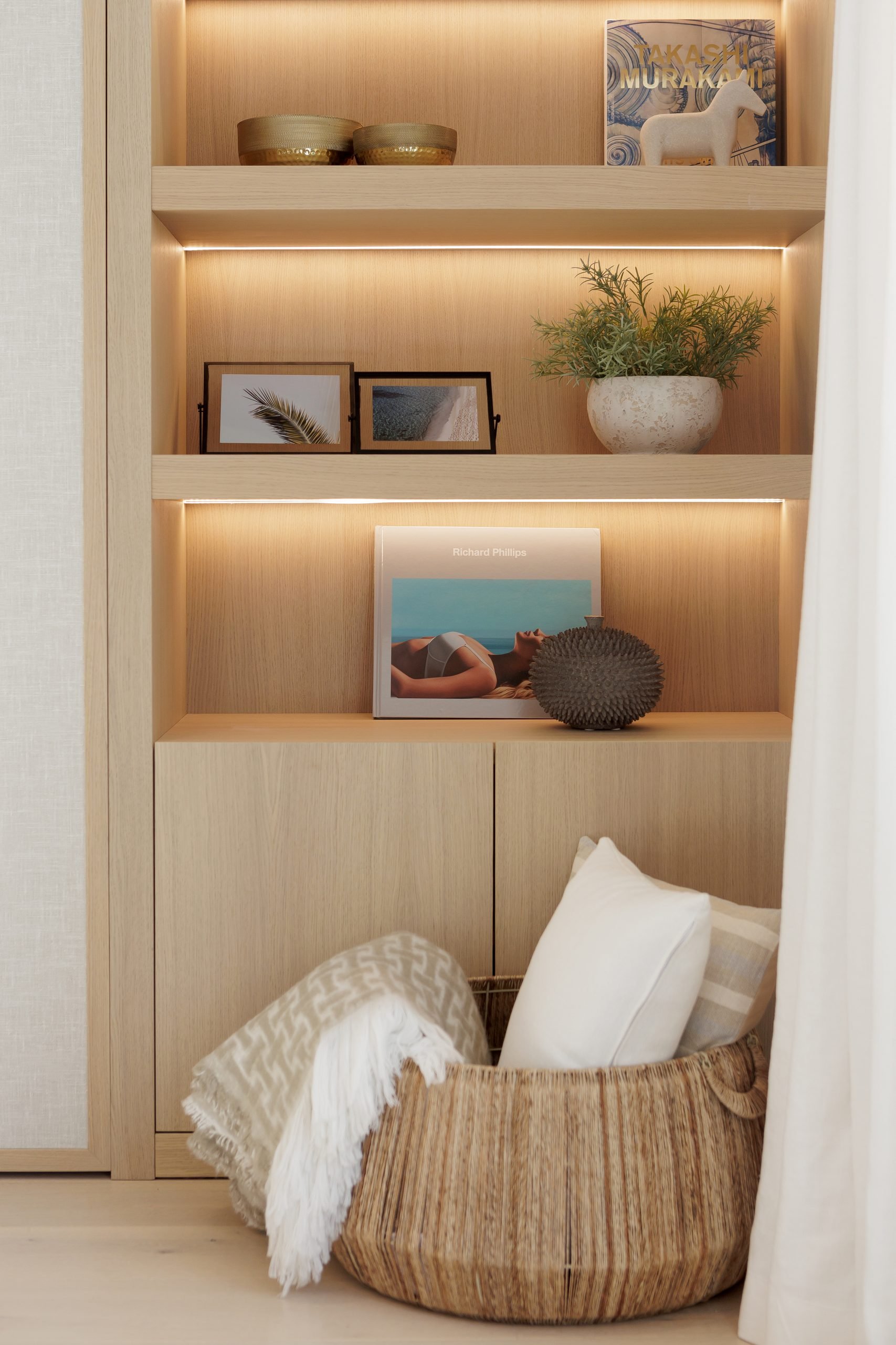 Estantería de madera con cojines y cesta — Grace Deco Nueva Andalucía, Nueva Andalucía, Marbella. Fotografía de Pedro Jaén