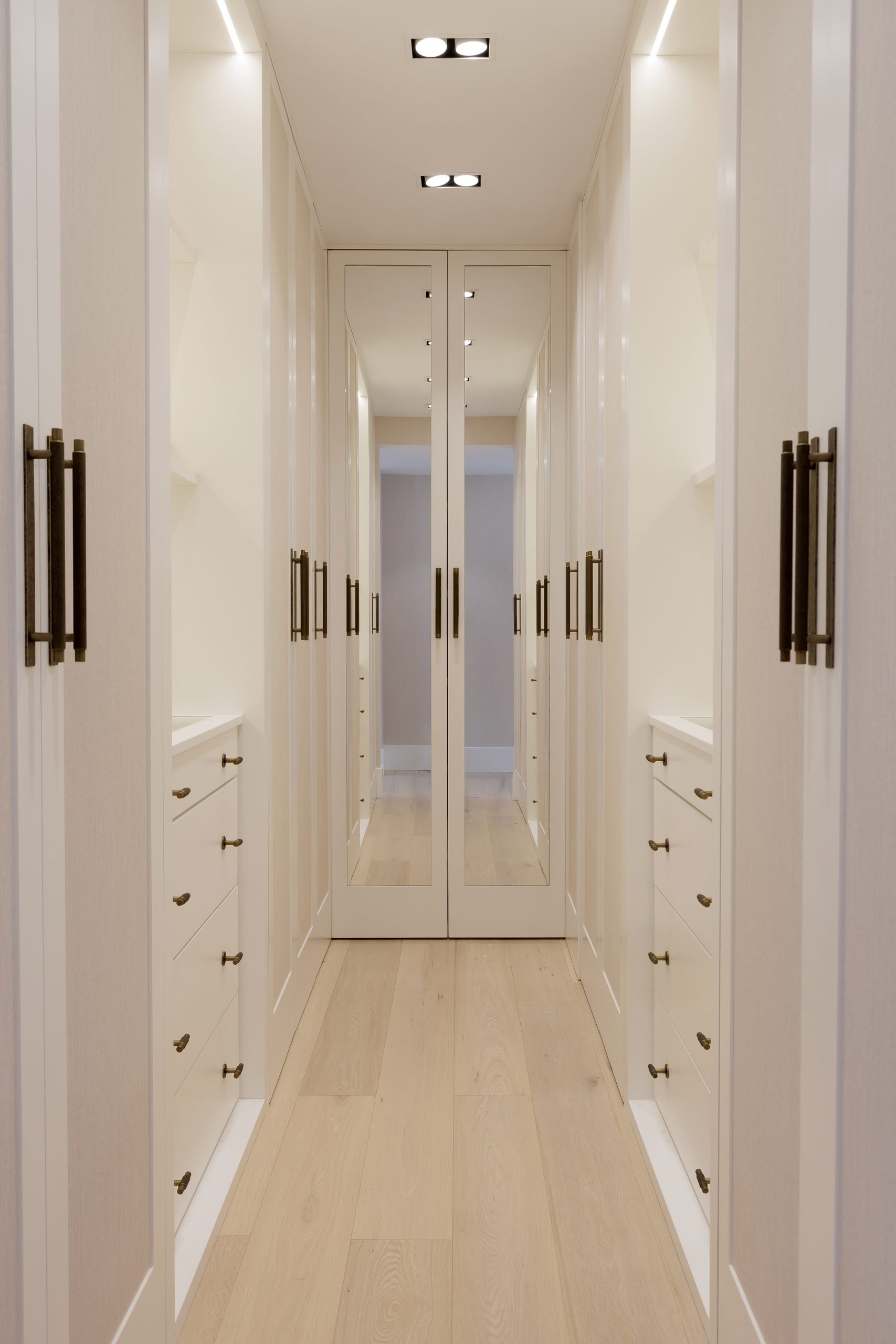 Vestidor en pasillo blanco con suelo de madera — Grace Deco Nueva Andalucía, Nueva Andalucía, Marbella. Fotografía de Pedro Jaén