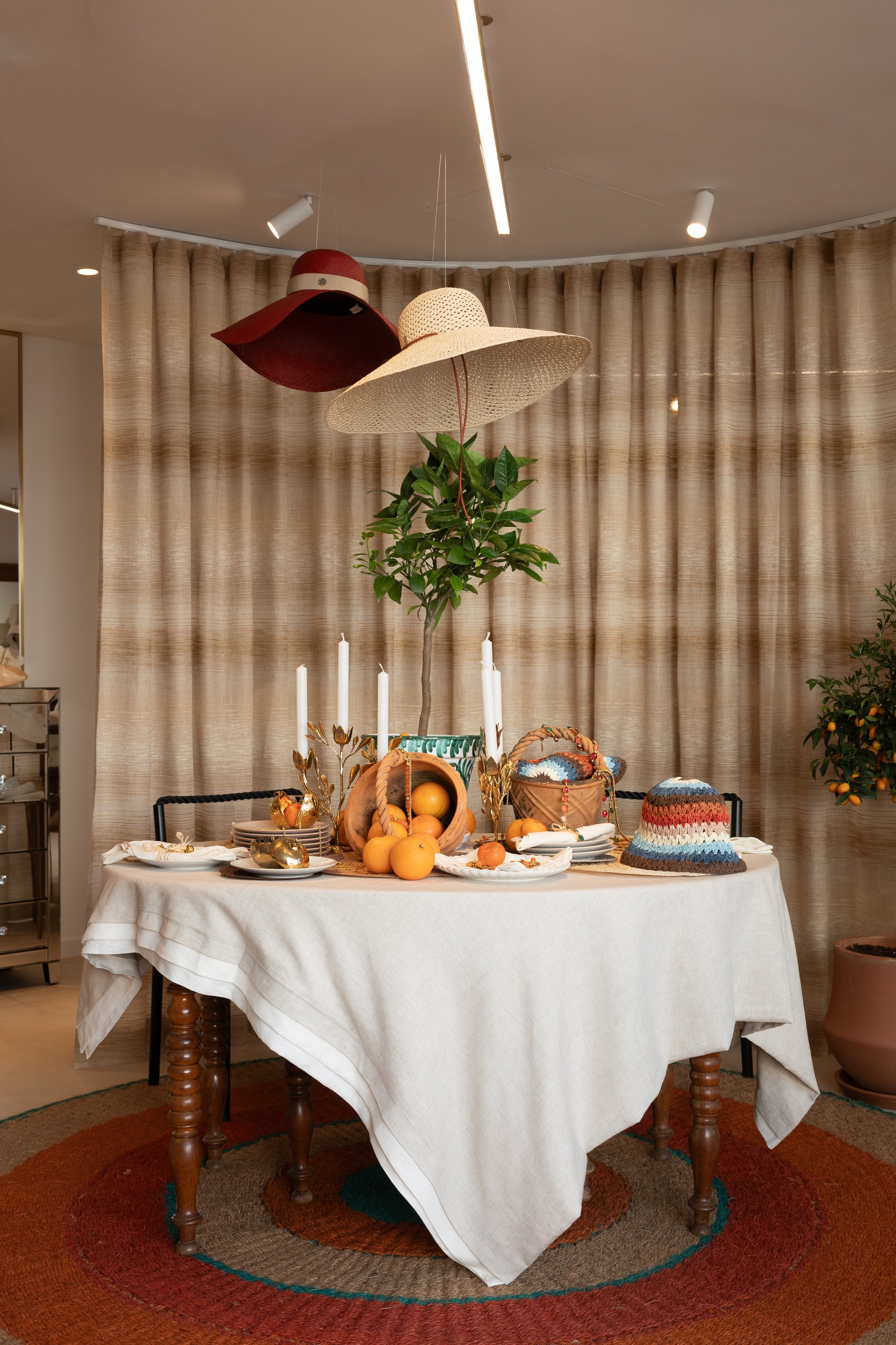 Mesa vestida con centro floral ante cortinas de rayas — Maison Michel + Goossens, Marbella Club Hotel, Marbella. Fotografía de Pedro Jaén