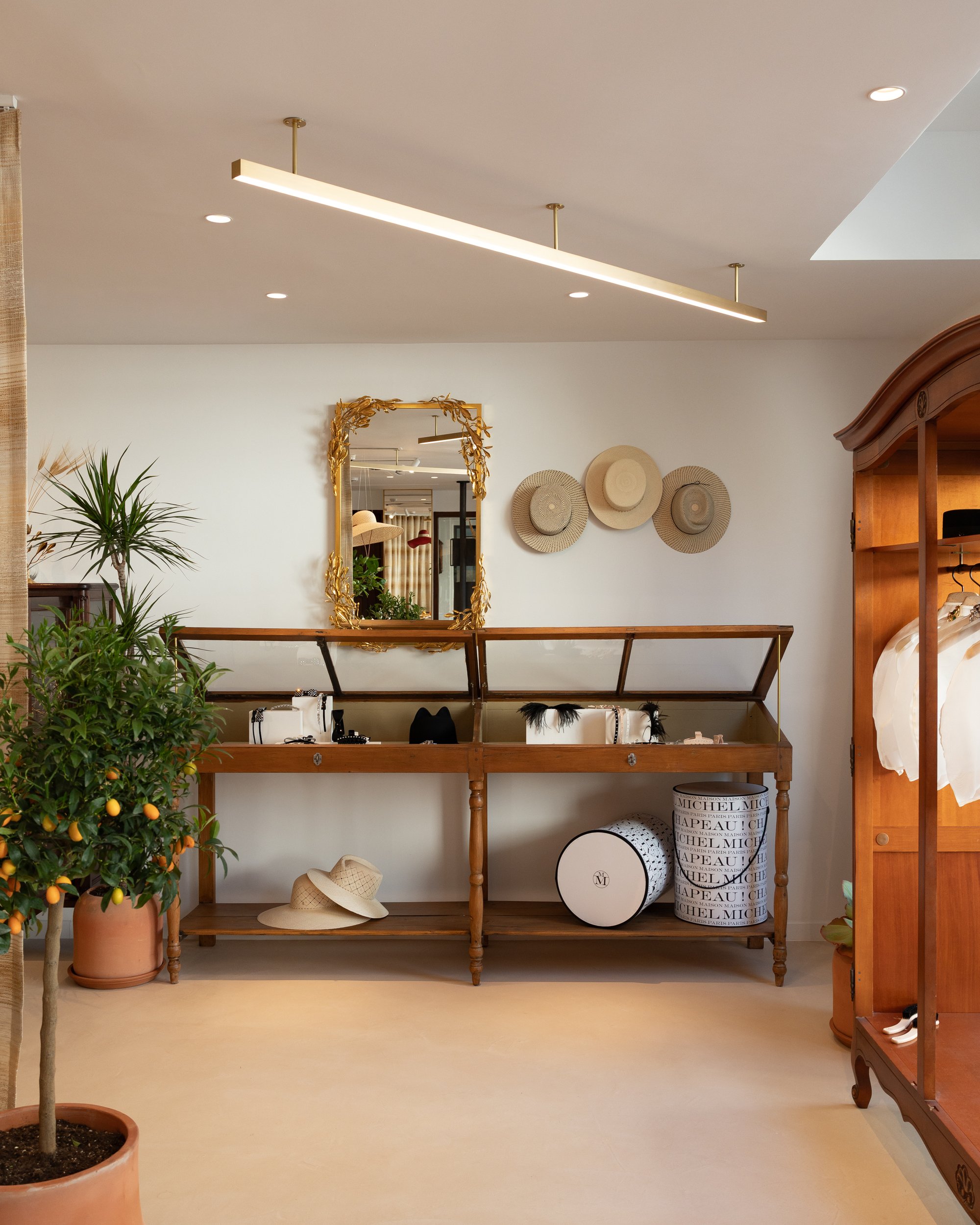 Sala de la boutique con mesa expositora de madera y plantas — Maison Michel + Goossens, Marbella Club Hotel, Marbella. Fotografía de Pedro Jaén