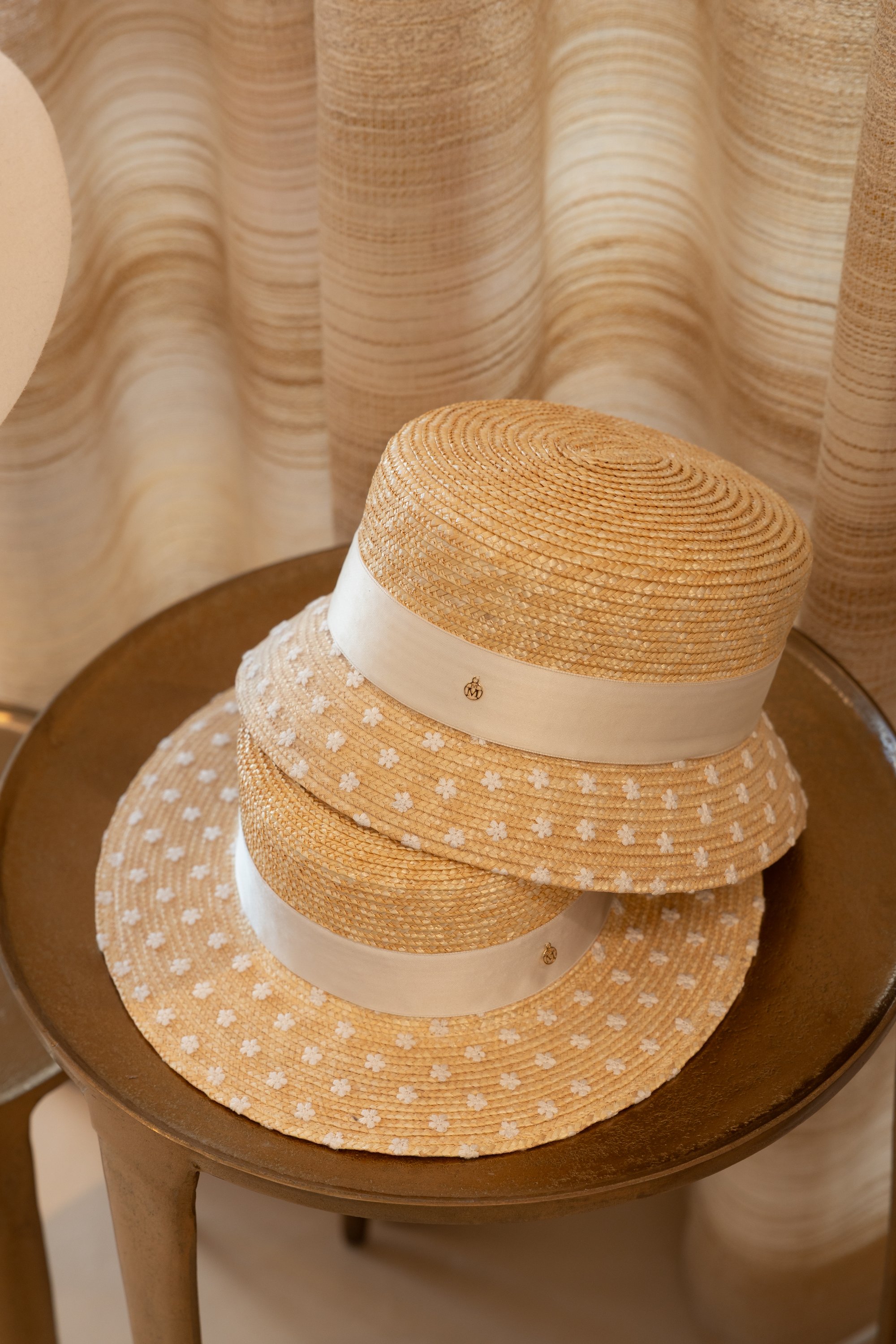 Detalle de sombreros de paja sobre mesa de madera — Maison Michel + Goossens, Marbella Club Hotel, Marbella. Fotografía de Pedro Jaén