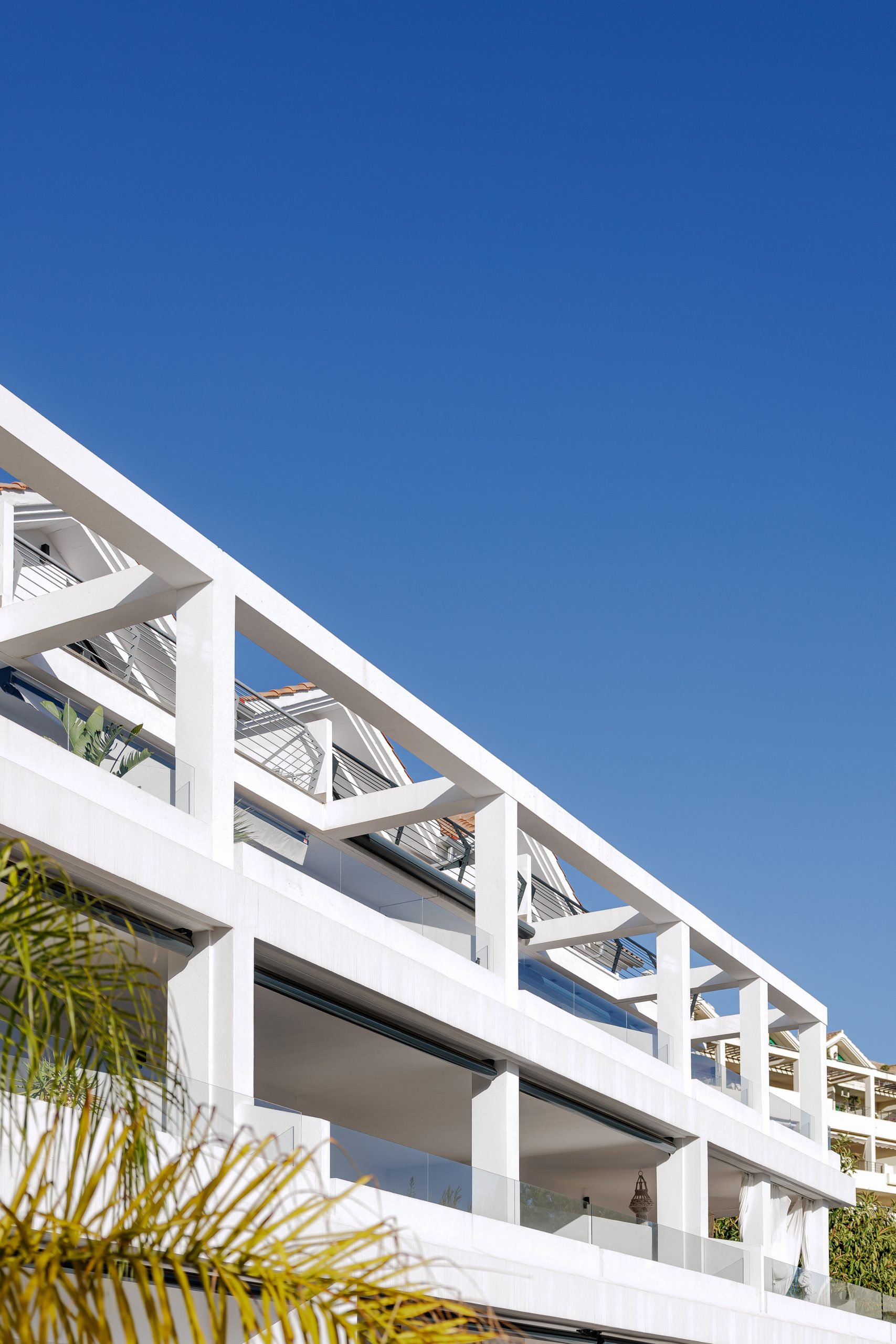Terrazas blancas escalonadas sobre cielo azul — Apartamento Selwo Ocean Hills, Costa del Sol. Fotografía de Pedro Jaén
