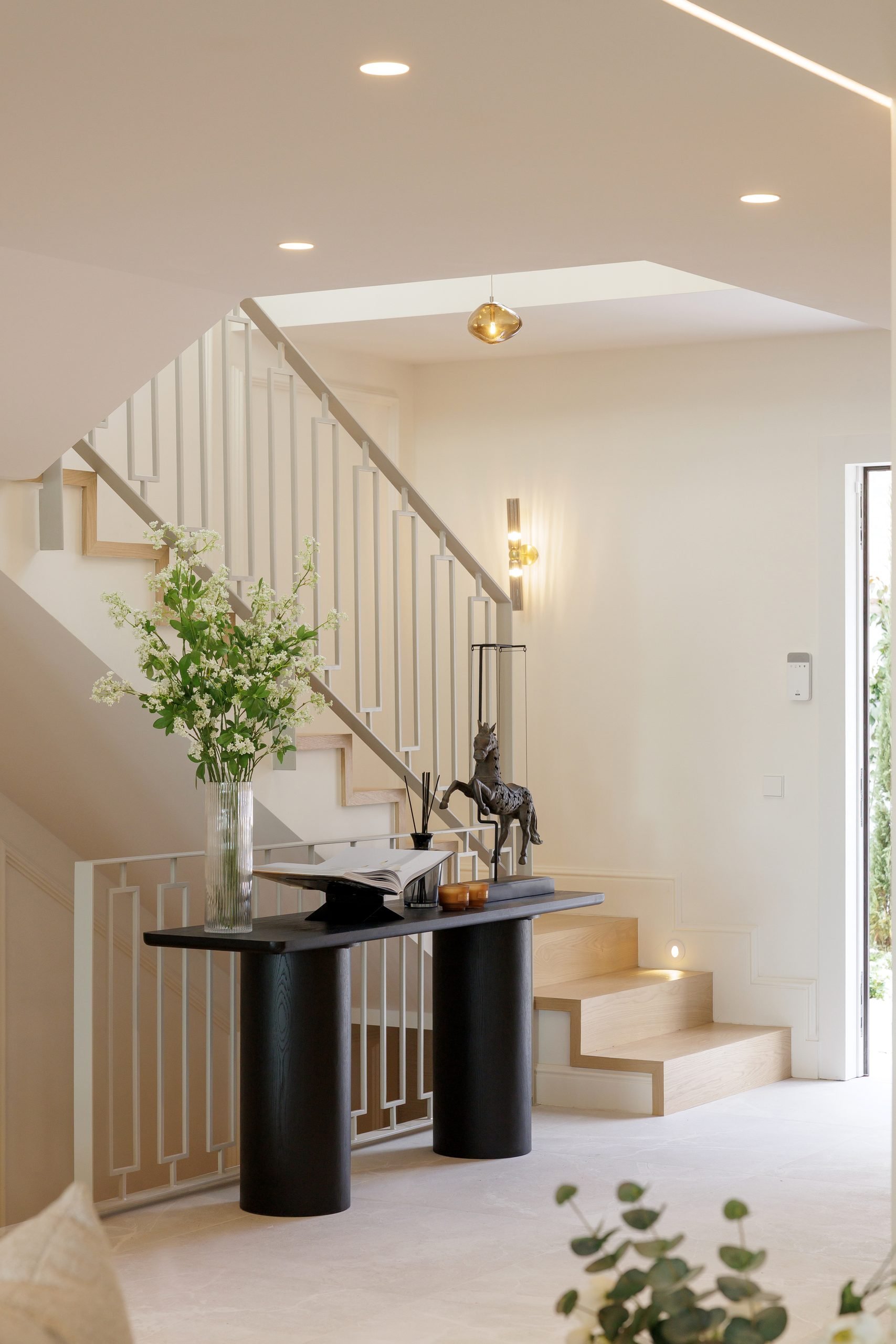 Recibidor con escalera y consola negra — Soledad Merchán Villa. Fotografía de Pedro Jaén