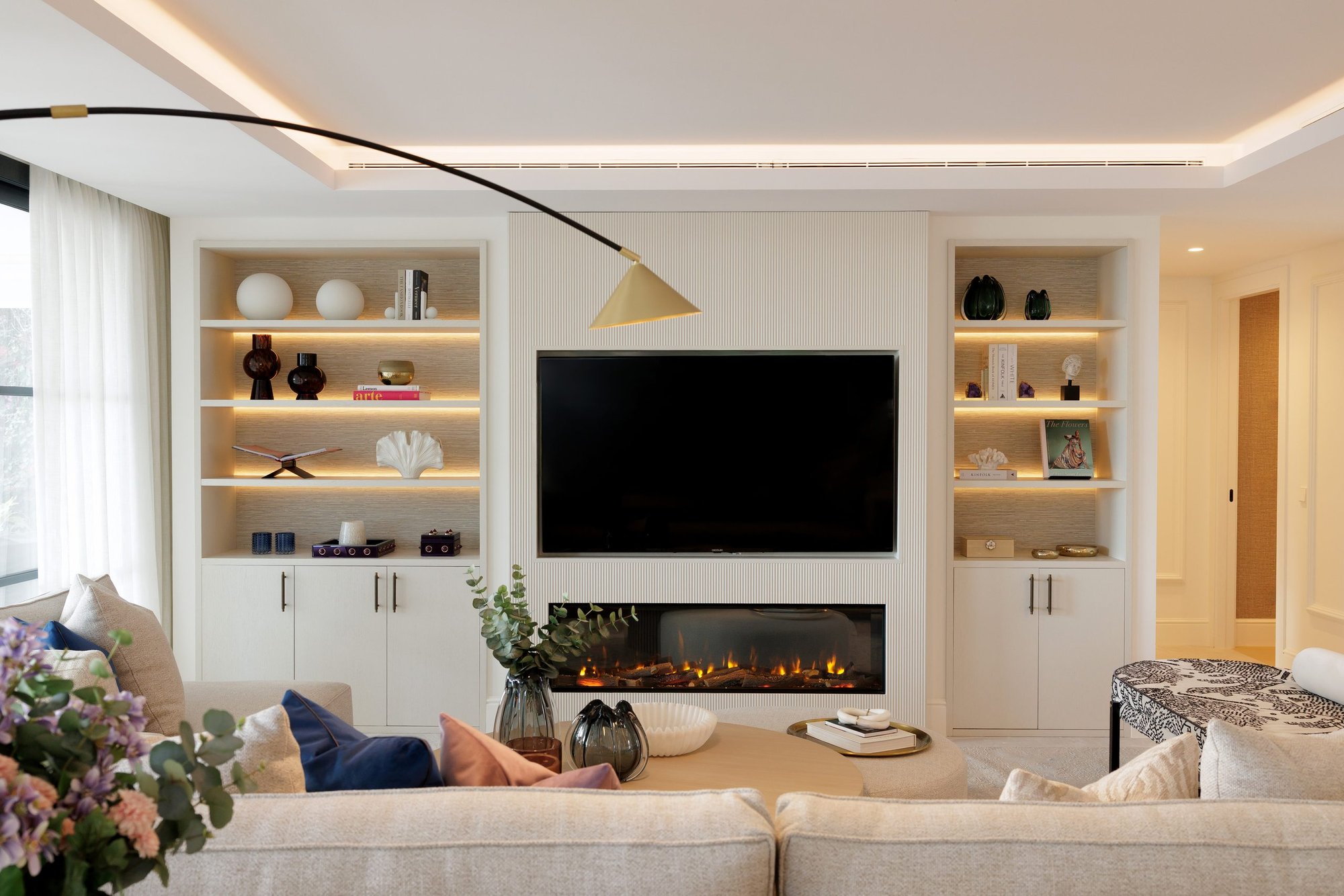 Salón con librerías iluminadas y chimenea — Soledad Merchán Villa. Fotografía de Pedro Jaén