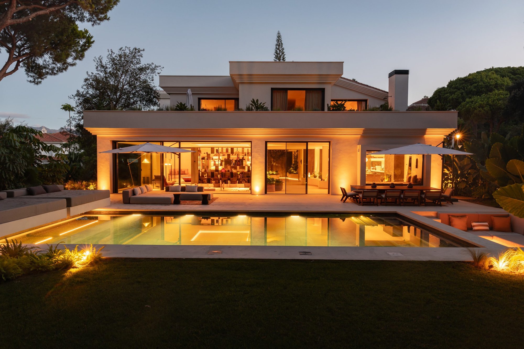 Fachada iluminada y piscina al atardecer — Villa Copal, Cabopino, Marbella. Fotografía de Pedro Jaén