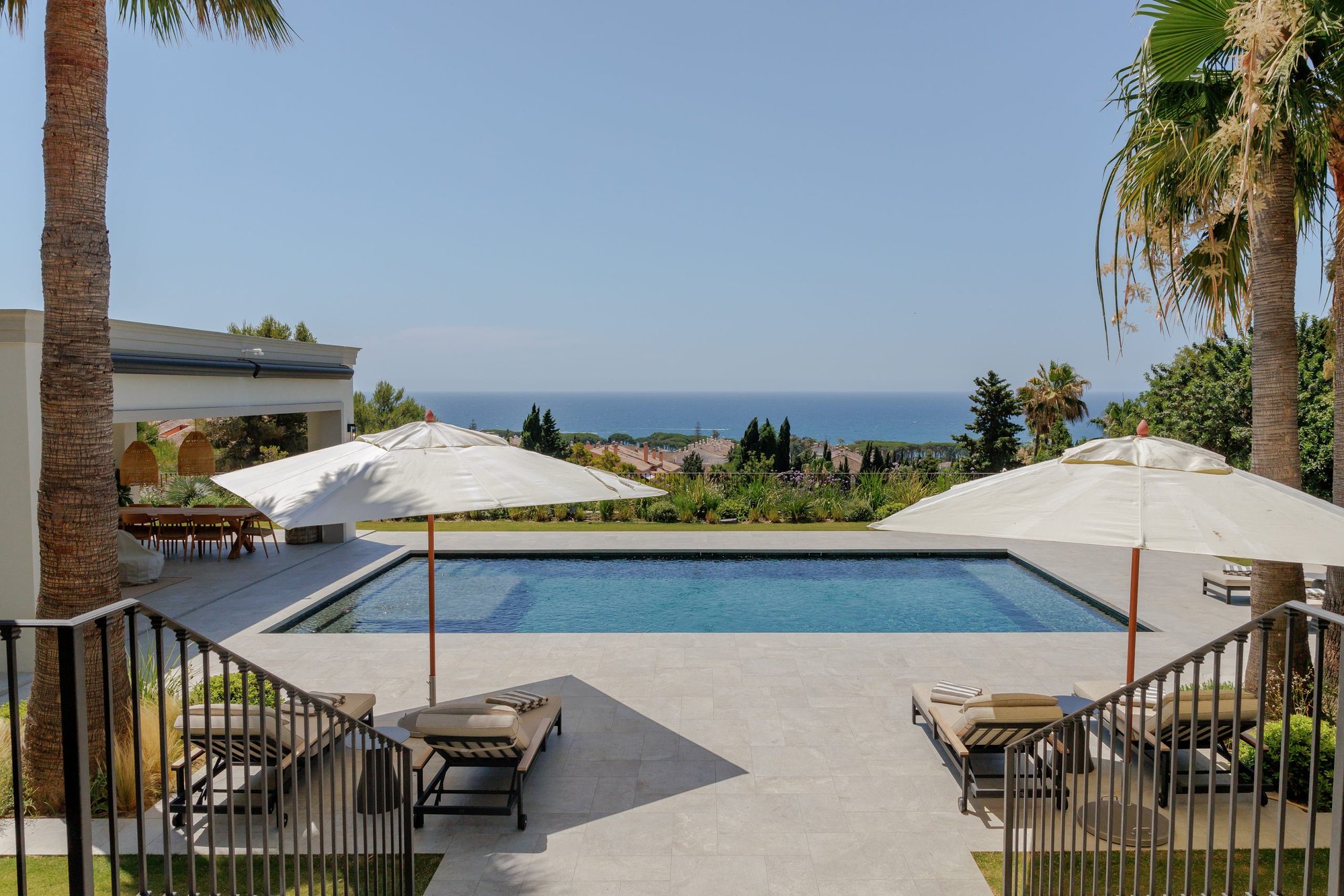 Piscina con sombrillas y vistas al mar — Villa Kronenburg, Nagüeles, Marbella. Fotografía de Pedro Jaén
