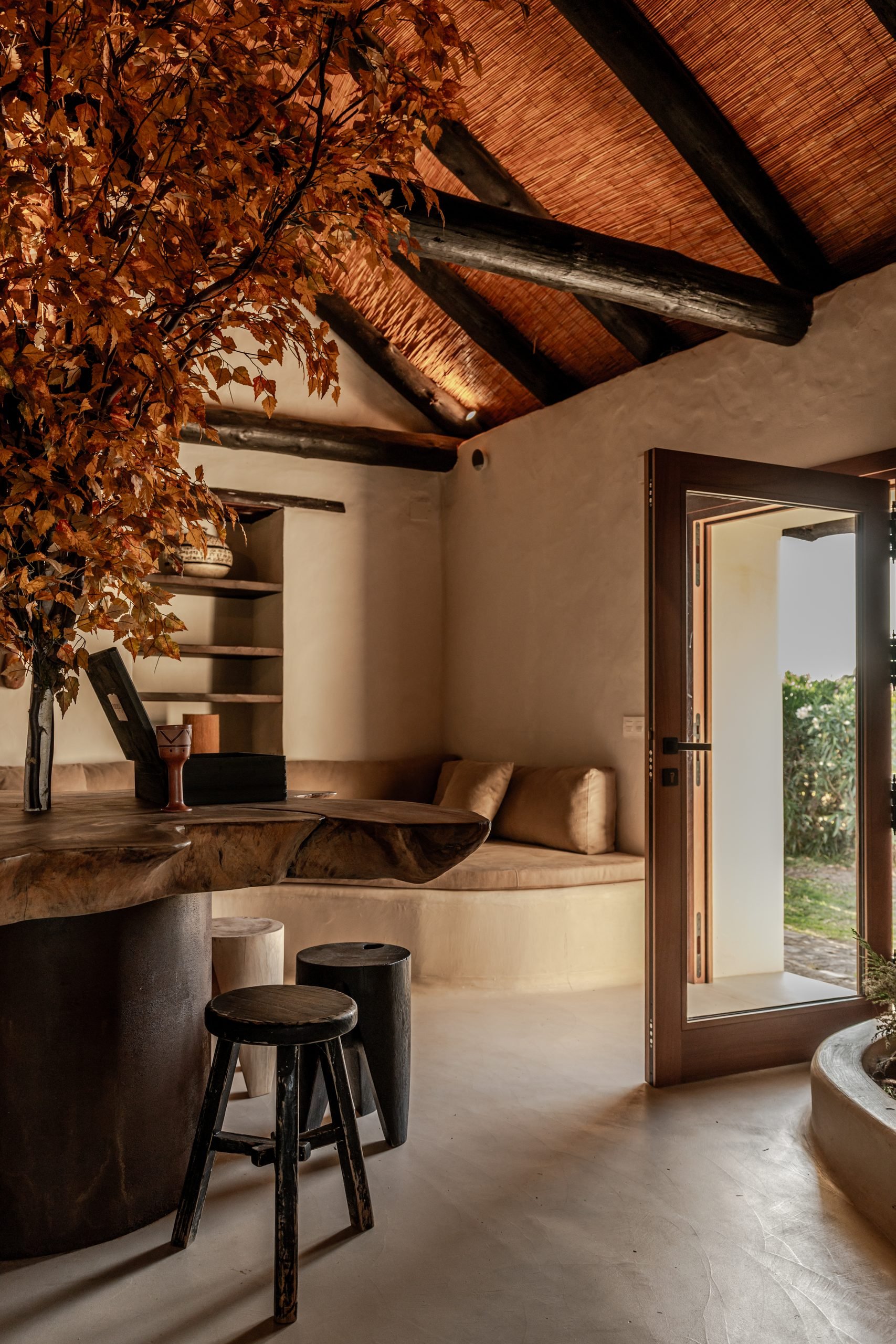 Rincón del salón con banco de obra y taburetes de madera — Villa The Cave, Tarifa, Cádiz. Fotografía de Pedro Jaén