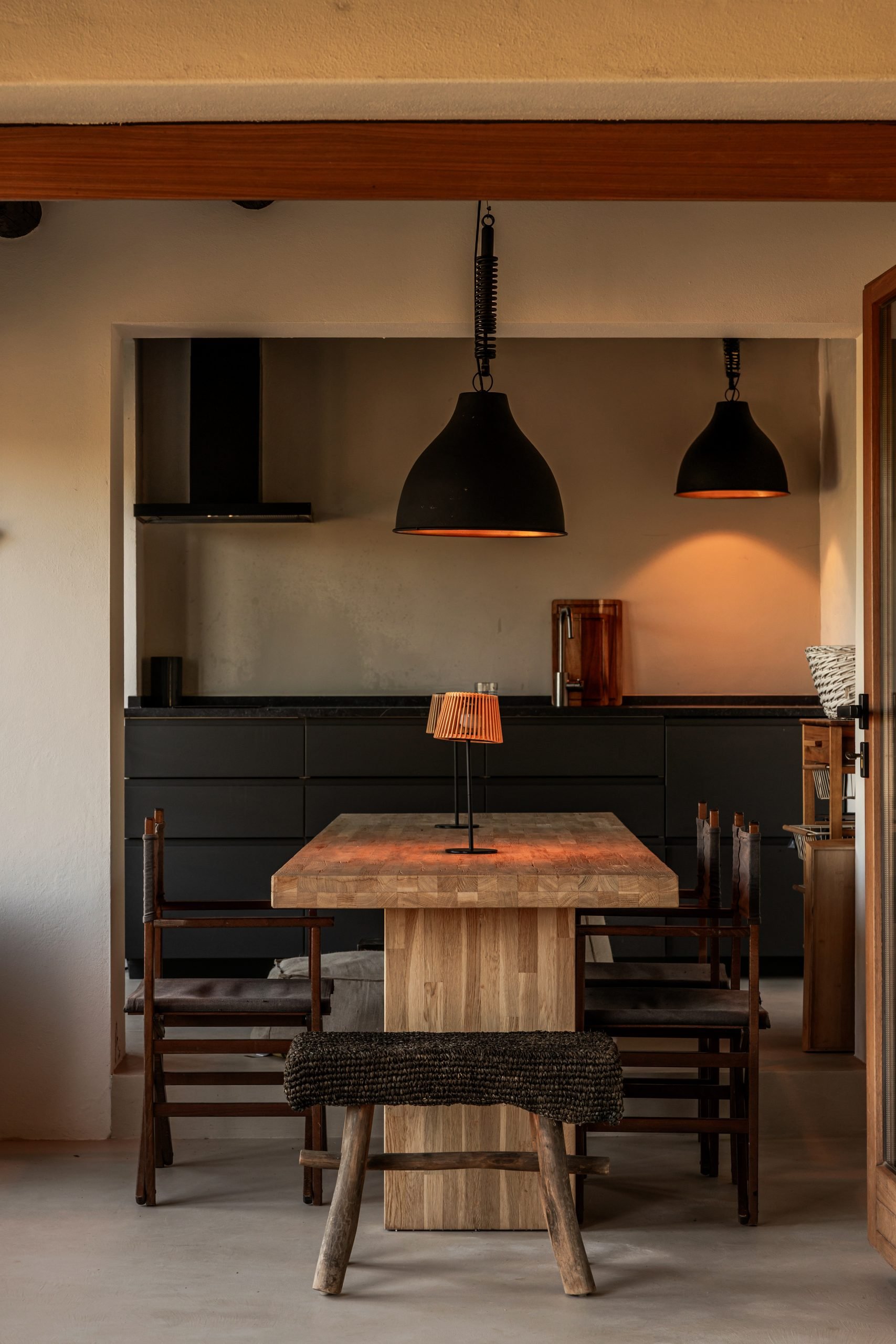 Comedor y cocina con lámparas negras colgantes — Villa The Cave, Tarifa, Cádiz. Fotografía de Pedro Jaén